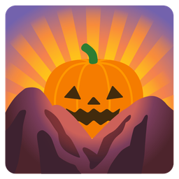 jack-o-lantern and sunrise over mountains