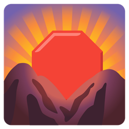 stop sign and sunrise over mountains